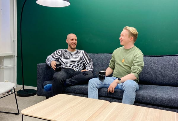 Arttu and Lare sitting on a couch drinking coffee and chatting